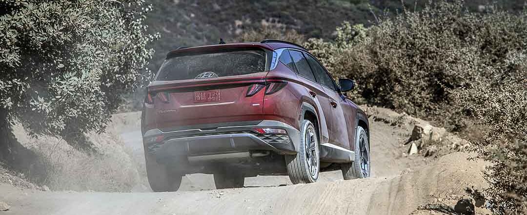 vue latérale arrière Hyundai Tucson 2022 sur une route de terre