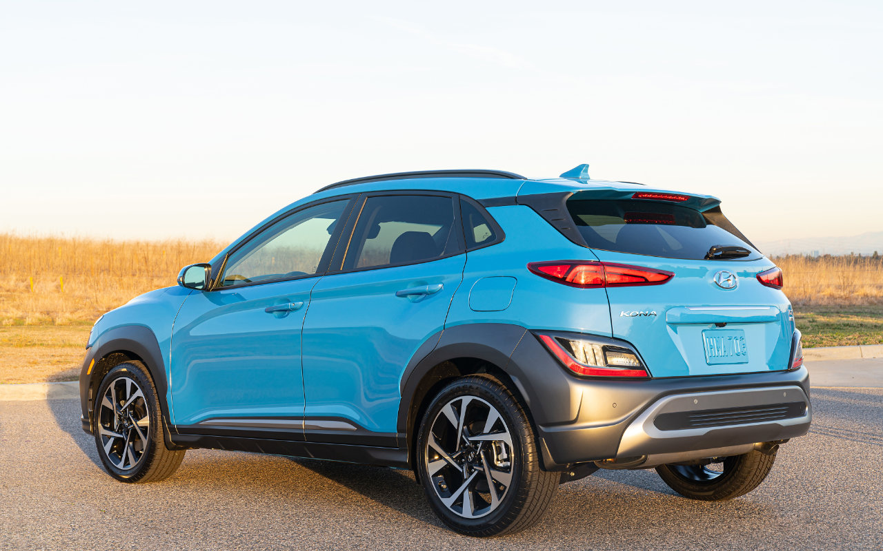 vue latérale arrière d'une Hyundai Kona 2023 dans un stationnement près d'un champ