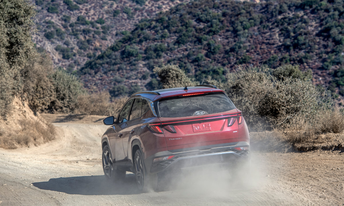 vue latérale arrière d'un Hyundai Tucson 2023 sur un sentier de terre en nature